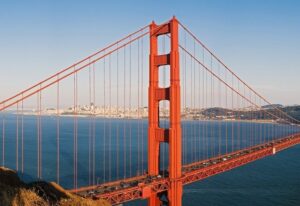 Iconic red suspension bridge spanning blue bay